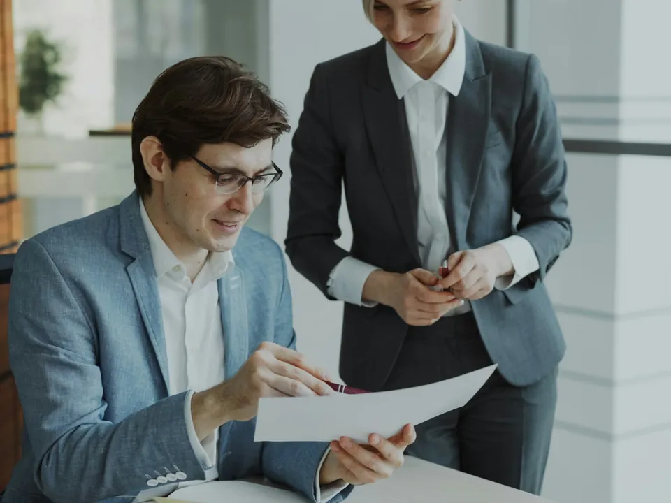 Two consultants reviewing a printed proposal together